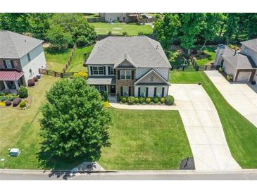 Two-story home featuring a well-manicured lawn and a spacious driveway, beautiful landscaping at 3420 Pleasant Springs Dr, Cumming, GA 30028
