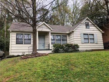 Charming single-story home with a well-maintained lawn, mature trees, and a cozy front porch at 901 Cumberland Rd, Atlanta, GA 30306