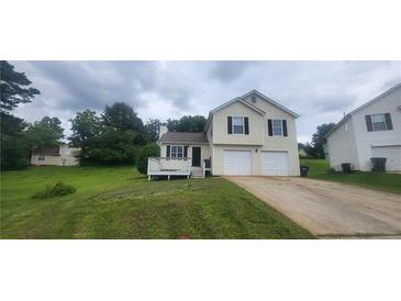 Inviting home featuring a well-maintained lawn, charming porch, and convenient two-car garage at 341 Brookside Dr, Mcdonough, GA 30253