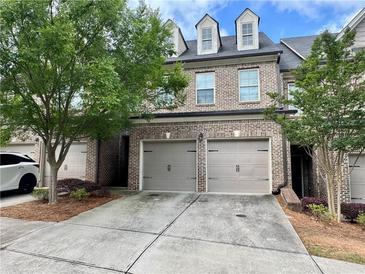 Charming brick townhome with a two-car garage and well-maintained landscaping at 5535 Bright Cross Way, Suwanee, GA 30024