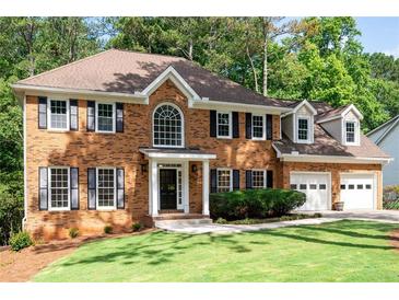 Charming brick home with two-car garage, manicured lawn, and inviting front entrance at 1096 Polo Club Nw Dr, Marietta, GA 30064