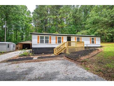 Charming single-story home with a welcoming porch and lush green surroundings at 12208 Buchanan Hwy, Temple, GA 30179