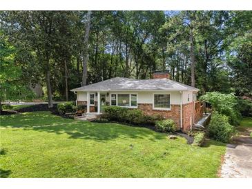 Charming single-story home with a brick facade, manicured lawn, and mature trees at 839 Cardova Ne Dr, Atlanta, GA 30324