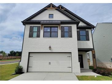 Charming two-story home with painted brick, garage, and dark accents at 11 Butternut Way, Auburn, GA 30011