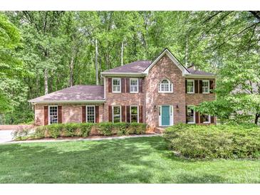 Charming brick two-story home featuring manicured landscaping, a lush green lawn, and a welcoming front entrance at 4259 Arbor Club Dr, Marietta, GA 30066