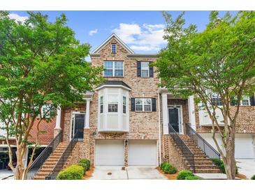 Charming brick townhome with two-car garage and landscaped front yard at 2988 Rivergreen Se Ln, Atlanta, GA 30339