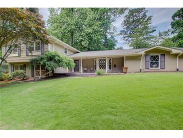 Expansive front yard and charming home exterior with mature trees and traditional architectural details at 4140 Candler Lake West Ne, Atlanta, GA 30319