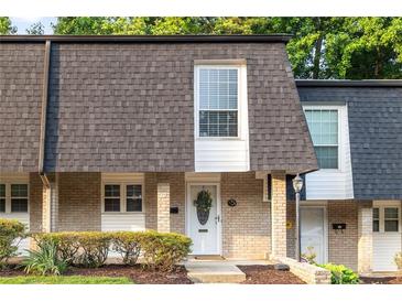 Charming townhome with brick facade, complemented by a well-manicured lawn and tasteful landscaping at 5170 Chemin De Vie Ne, Sandy Springs, GA 30342