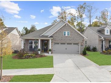 Charming, single-story brick home featuring a well-manicured lawn and a two-car garage at 218 Floral Valley Dr, Woodstock, GA 30188