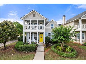 Charming two-story home featuring a welcoming porch, a bright yellow door, and manicured landscaping at 240 Daisy Cir, Mcdonough, GA 30252