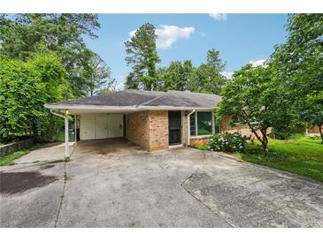 Charming single-story brick home with a covered carport and lush, mature landscaping creating curb appeal at 2880 Shallowford Rd, Chamblee, GA 30341