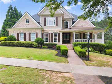 Charming two-story home with manicured lawn, brick walkway, and inviting front porch at 4526 Meadow Club Dr, Suwanee, GA 30024