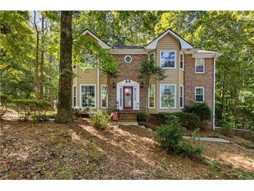Charming two-story home with brick and siding exterior and beautiful mature trees at 119 Castlewood Rd, Tyrone, GA 30290