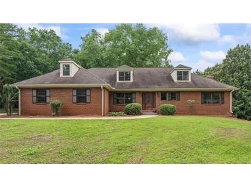 Charming one-story brick home with a well-manicured lawn and mature trees at 103 Seabolt Dr, Locust Grove, GA 30248