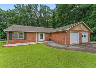 Charming brick home with a well-manicured lawn and two-car garage, perfect for suburban living at 1738 Sherry Ln, Jonesboro, GA 30236