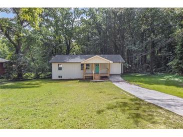 Charming home featuring a freshly landscaped yard, long driveway, and inviting front porch at 2128 Kimberly Rd, Atlanta, GA 30331