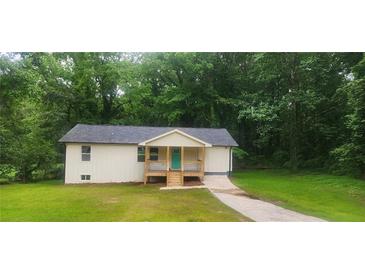 Charming single-story home with a cozy front porch and a driveway in a lush, wooded setting at 2128 Kimberly Rd, Atlanta, GA 30331