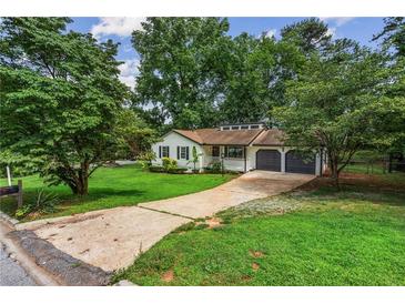 Charming single-story home with a well-manicured lawn and an attached two-car garage at 3833 Paddington Trail, Rex, GA 30273