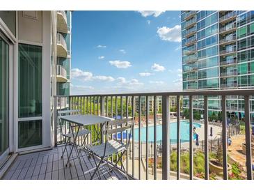 Relaxing balcony area with seating overlooking a sparkling community pool and lush landscaping at 943 Peachtree Ne St # 902, Atlanta, GA 30309