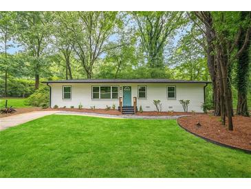 Charming home featuring a freshly manicured lawn and a striking turquoise front door at 3160 Ann Se Rd, Smyrna, GA 30080