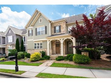 Charming two-story home with stone accents, a covered front porch, and mature landscaping at 238 Avery Ne St, Marietta, GA 30060