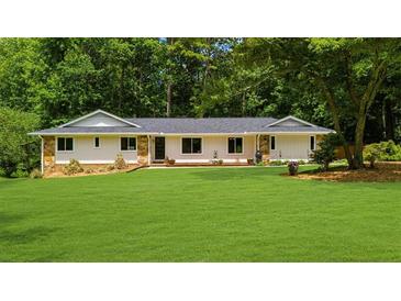 Ranch-style home showcasing its well-maintained lawn, stone accents, and inviting curb appeal at 1035 Hunterhill Dr, Roswell, GA 30075