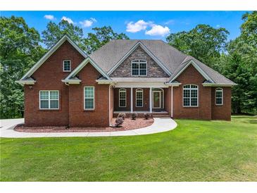 Beautiful brick home featuring manicured lawn and complementing stone accents at 6020 Cochran Mill Rd, Palmetto, GA 30268