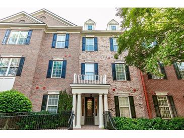 Elegant brick townhouse with dark shutters, stately columns, and well-maintained landscaping at 4810 Ivy Ridge Se Dr # 303, Atlanta, GA 30339