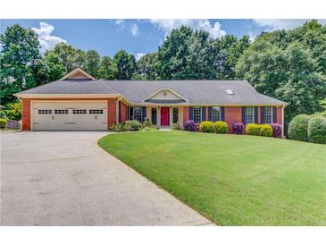 Charming single-story brick home with a well-manicured lawn and colorful landscaping, plus a 2 car garage at 3550 Miller Farms Ln, Peachtree Corners, GA 30096