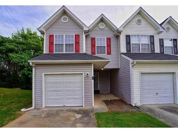 Charming townhome featuring attached garages, gray siding, and symmetrical window design at 6927 Gallant Se Cir # 11, Mableton, GA 30126