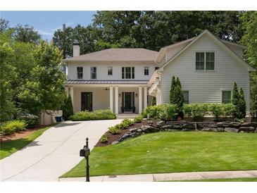Charming two-story home boasts a landscaped yard and long driveway at 633 Channing Nw Dr, Atlanta, GA 30318