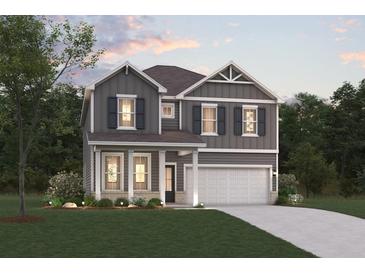 Charming two-story home featuring gray siding, black shutters, and a well-manicured front lawn at 2625 Mourning Dove Dr (Lot 47), Grayson, GA 30017