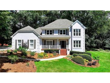 Charming two-story home with a landscaped front yard, a welcoming porch, and a symmetrical design at 9585 Fenbrook Ct, Johns Creek, GA 30022