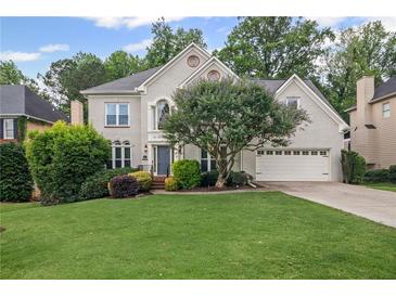 Charming two-story home with well-manicured lawn and mature landscaping, with an attached two car garage at 640 Windwalk Dr, Roswell, GA 30076