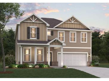 Charming two-story home boasts a two-car garage, manicured lawn, and traditional architectural details at 2645 Mourning Dove Drive (Lot 49), Grayson, GA 30017
