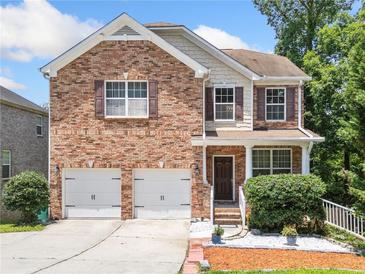 Charming two-story brick home with a two-car garage and a well-manicured front yard at 6018 Oakdale Se Rd, Mableton, GA 30126