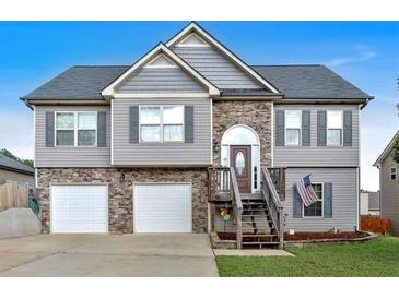 Charming two-story home featuring a two-car garage, stone accents, and a well-maintained front lawn at 218 Depot Ln, Dallas, GA 30157