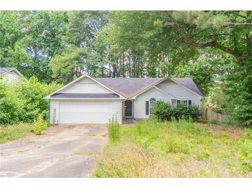 Ranch-style house with a two-car garage and an overgrown front yard at 20 Rosebud Ln, Mcdonough, GA 30253