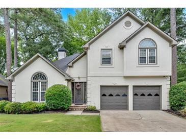 Charming traditional two-story home with a well-manicured lawn and an attached two-car garage at 3473 Whisperwood Nw Ct, Marietta, GA 30064