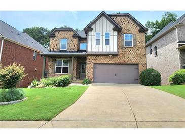 Charming two-story brick home with a well-manicured lawn and a two-car garage at 827 Autry Oak Ct, Johns Creek, GA 30022