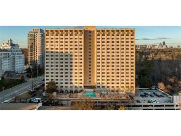 High-rise apartment building featuring an outdoor pool, parking, and views of the surrounding city skyline at 2479 Peachtree Ne Rd # 1714, Atlanta, GA 30305