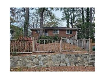 Charming brick home featuring mature trees and a stone retaining wall at 1917 Penelope Nw Rd, Atlanta, GA 30314
