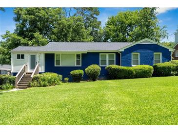 Charming blue home featuring a lush green lawn, manicured shrubs, and inviting front steps at 2011 Lexington Ave, Atlanta, GA 30344