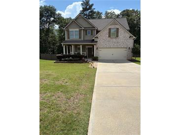 Charming two-story home with a manicured lawn, brick accents, and a welcoming front porch at 124 Gorham Gates Ct, Hiram, GA 30141