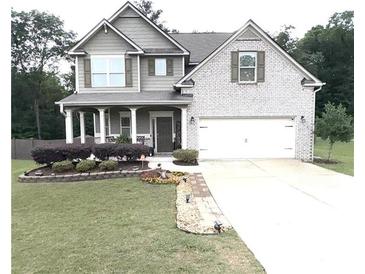 Charming two-story home featuring a landscaped yard, inviting front porch, and a convenient two-car garage at 124 Gorham Gates Ct, Hiram, GA 30141