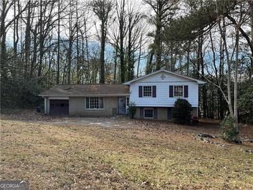 Charming split-level home with a large front yard and a one car garage in a private, wooded setting at 905 Nw Magna Carta Dr, Atlanta, GA 30318