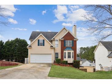 Charming two-story home featuring a brick facade, a two-car garage, and a well-manicured front lawn at 5686 Grindstone Dr, Buford, GA 30518