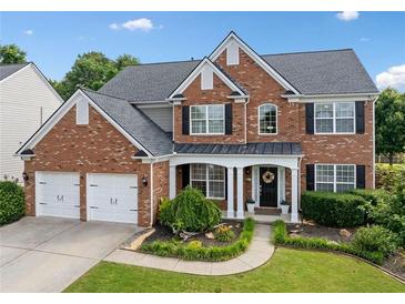 Charming two-story brick home with a well-manicured front yard and two car garage at 3850 Calomel Dr, Cumming, GA 30040