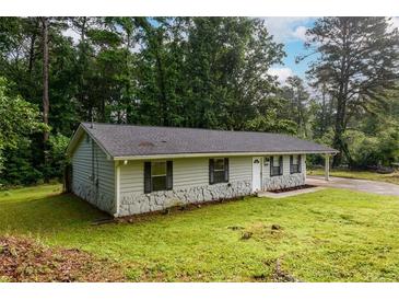 Charming single-story home featuring stone accents, a well-maintained lawn, and a covered carport at 3645 Shrewsbury Ct, Snellville, GA 30039