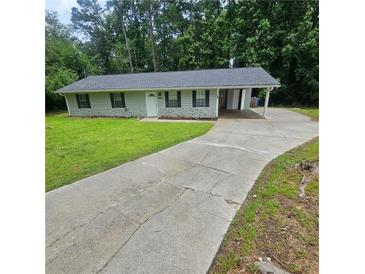 Charming single story home featuring a covered carport and a long driveway at 3645 Shrewsbury Ct, Snellville, GA 30039